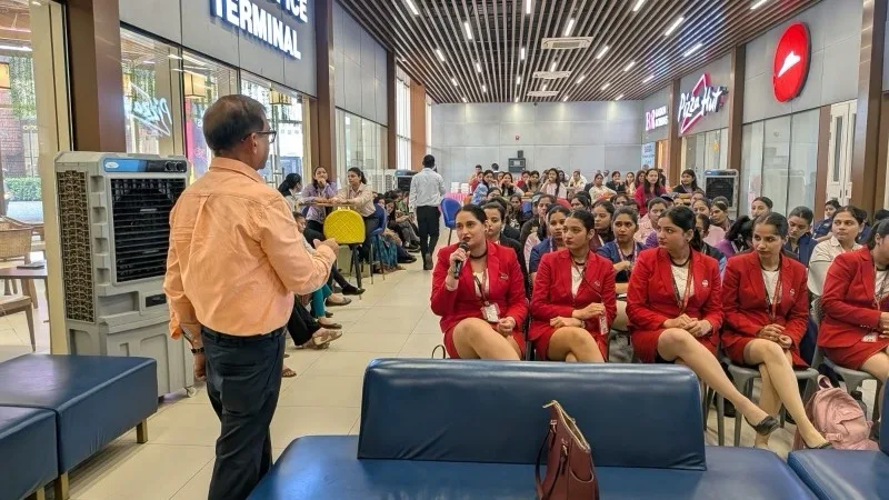 Dr. Sunita speaking on stage at Women's Day event, Ahmedabad Airport
