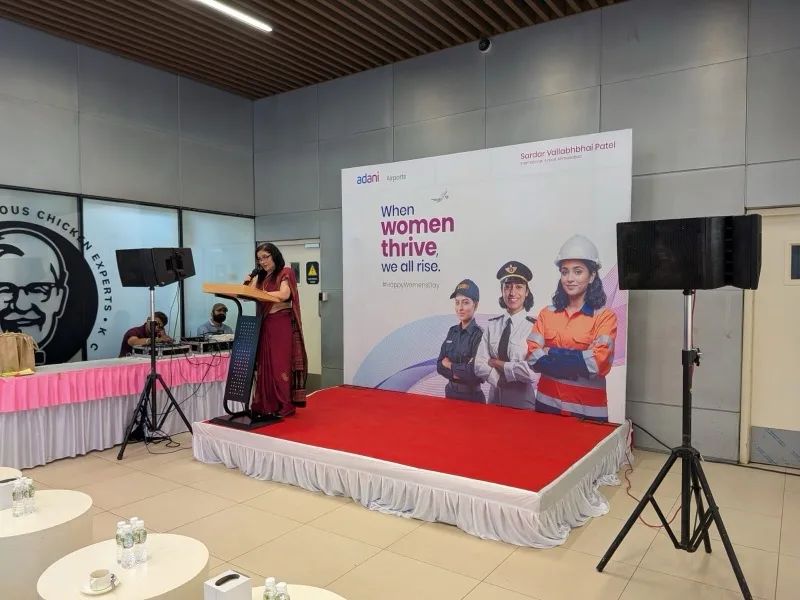 Dr. Sunita Sajnani on stage speaking about women's health at Ahmedabad Airport