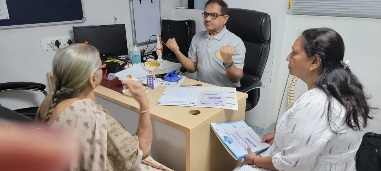 Dr. Ashok Sajnani consulting with a patient at Adinath Hospital